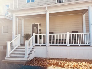 A two-story house with a front porch, a staircase, and a mailbox.