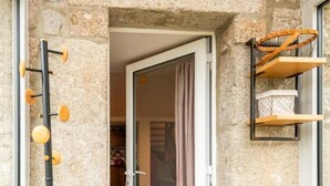 A stone-walled entryway with a bench, a coat rack, and a shelf with baskets. - Gîte La Parro - MALBOUZON (MALBOUZON)