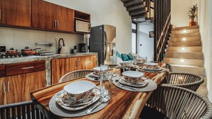 Una cucina moderna con mobili in legno, forno a microonde integrato e frigorifero in acciaio inossidabile.