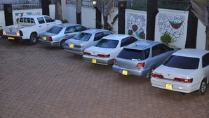 A row of parked cars in a parking lot with a paved surface. - City Side Hotels and Apartments Mukono (Mukono)