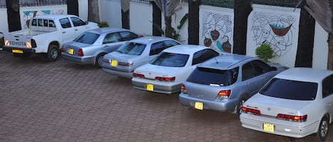 A row of parked cars in a parking lot with a paved surface.