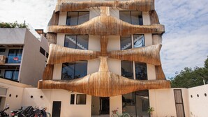 Un edificio de varios pisos con una fachada original que recuerda a la caña de bambú.