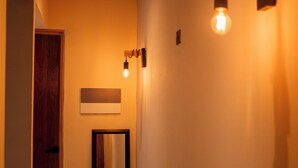Un pasillo con una puerta de madera, un espejo e iluminación empotrada.