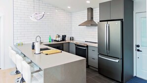 Una cocina moderna con una isla central, electrodomésticos de acero inoxidable e iluminación empotrada.
