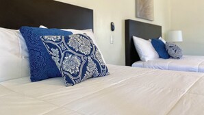 A hotel room with two beds, each with white bedding and blue patterned pillows. - Casa Anguiano Valle de Guadalupe (Valle de Guadalupe)