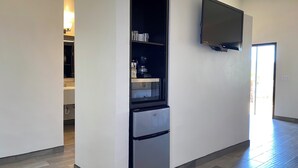 A modern kitchen with a built-in refrigerator, a microwave, and a flat-screen TV mounted on the wall. - Casa Anguiano Valle de Guadalupe (Valle de Guadalupe)