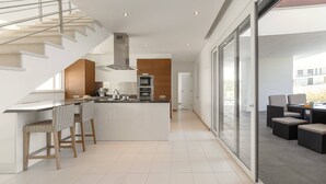 A modern kitchen with a central island, bar stools, and a staircase. - Poolside and Seaview Villa (Lisboa)