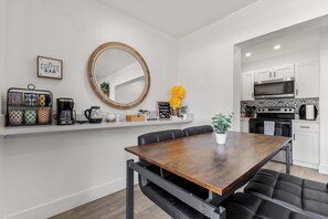 Une cuisine moderne avec des meubles blancs, un four à micro-ondes et une cuisinière.