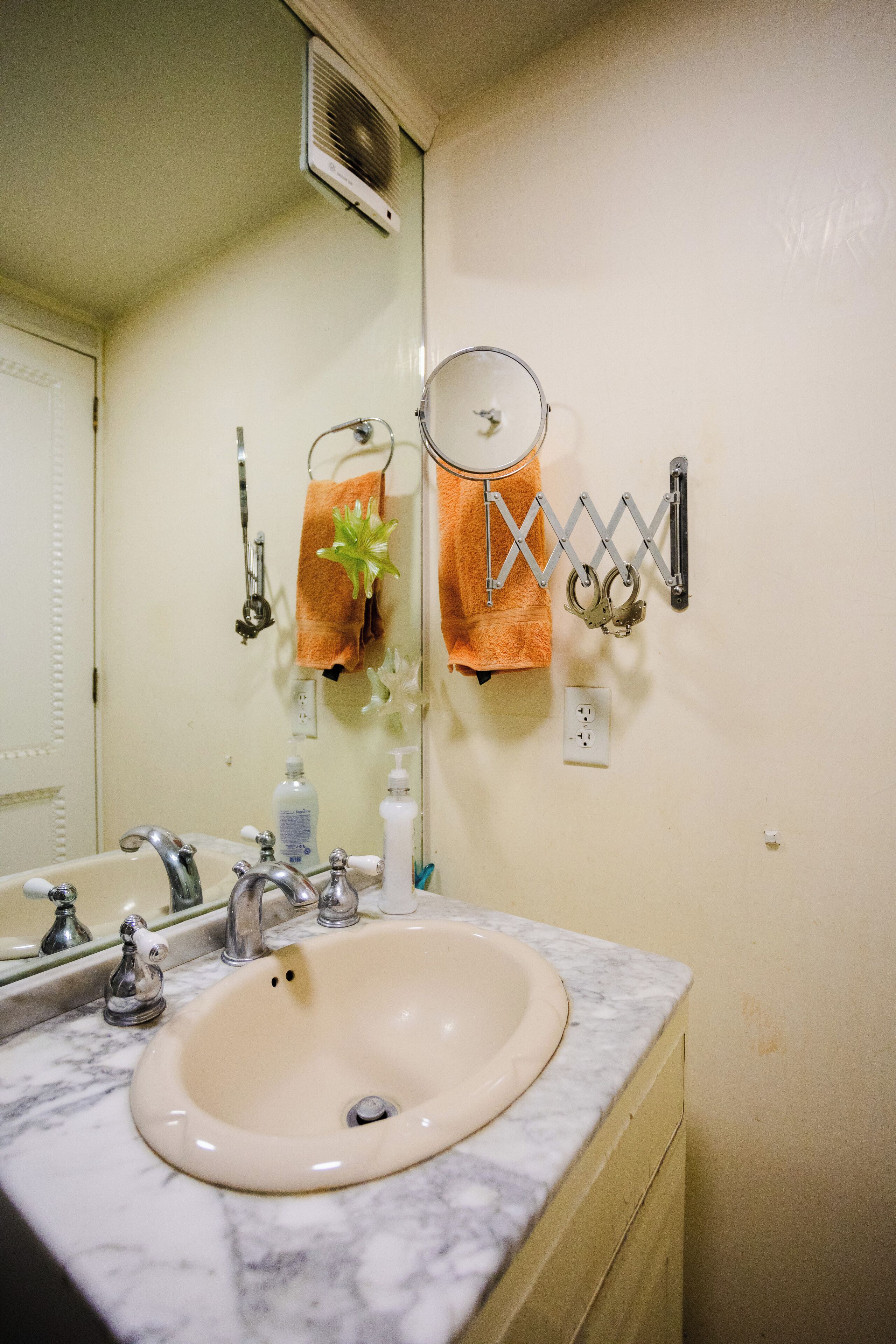Casa de banho com lavatório, espelho, porta-toalhas e aquecedor de parede.