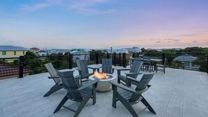 Une terrasse sur le toit, dotée d’un foyer entouré de chaises, d’où l’on peut admirer la vue sur la ville.