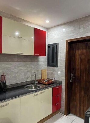 Enjoy cooking in this well-equipped kitchen with a stainless steel sink, wooden cutting board, and dish rack.
