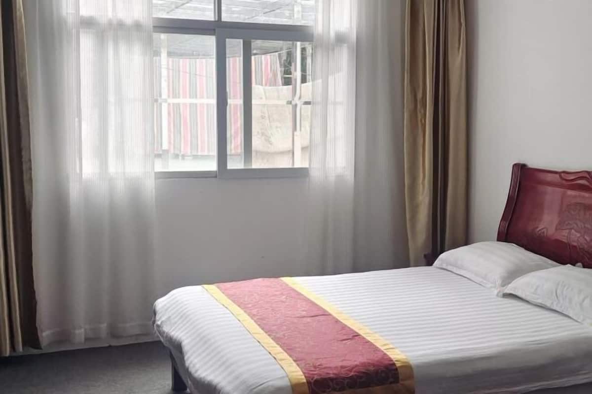 Un dormitorio con cama, cortinas y ventana.