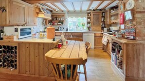 A spacious kitchen with wooden cabinets, a central island, and a dining area.