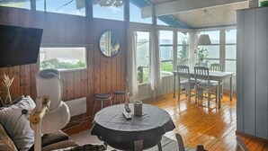 Una habitación acogedora con paredes de madera, una mesa redonda con mantel y un comedor con sillas.