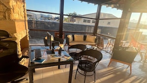 A covered outdoor seating area with a table, chairs, and a sofa. - Pousada Jet Club Marine Angra (Angra dos Reis)