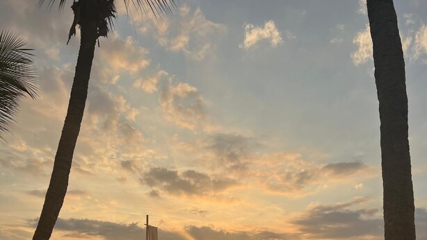 A sunset view from a poolside area with lounge chairs and a pergola. - Pousada Jet Club Marine Angra (Angra dos Reis)