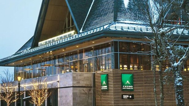 A modern building with a large glass facade, wooden exterior, and a sign indicating a casino.