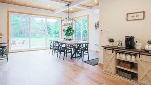 Et rummeligt køkken med spiseplads, store vinduer og en kaffebar.