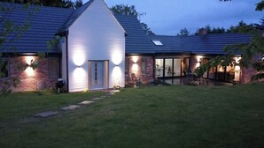 Una casa con fachada blanca, detalles de ladrillo y techo inclinado.