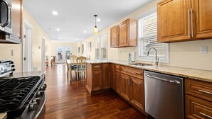 A kitchen with wooden cabinets, a stainless steel dishwasher, and a gas stove. - Bay view-walk to beach/boards/restaurants, parking (Ventnor City)