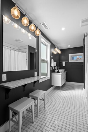 A modern bathroom with a large mirror, vanity, and bench. - Orange Loop-walk to beach & bars. Beach block (Atlantic City)