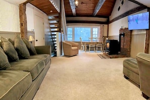 Una sala de estar acogedora con sofá, sillón y chimenea.