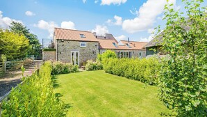 A stone house with a tiled roof, a stone entrance, and a well-maintained lawn. - 1 bedroom accommodation in Pickering (Pickering)