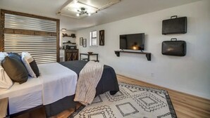 Une chambre à coucher avec un lit, une télévision et un luminaire au plafond.
