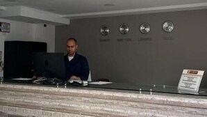 Bancada de recepção com parede estampada e placa indicando um restaurante.
