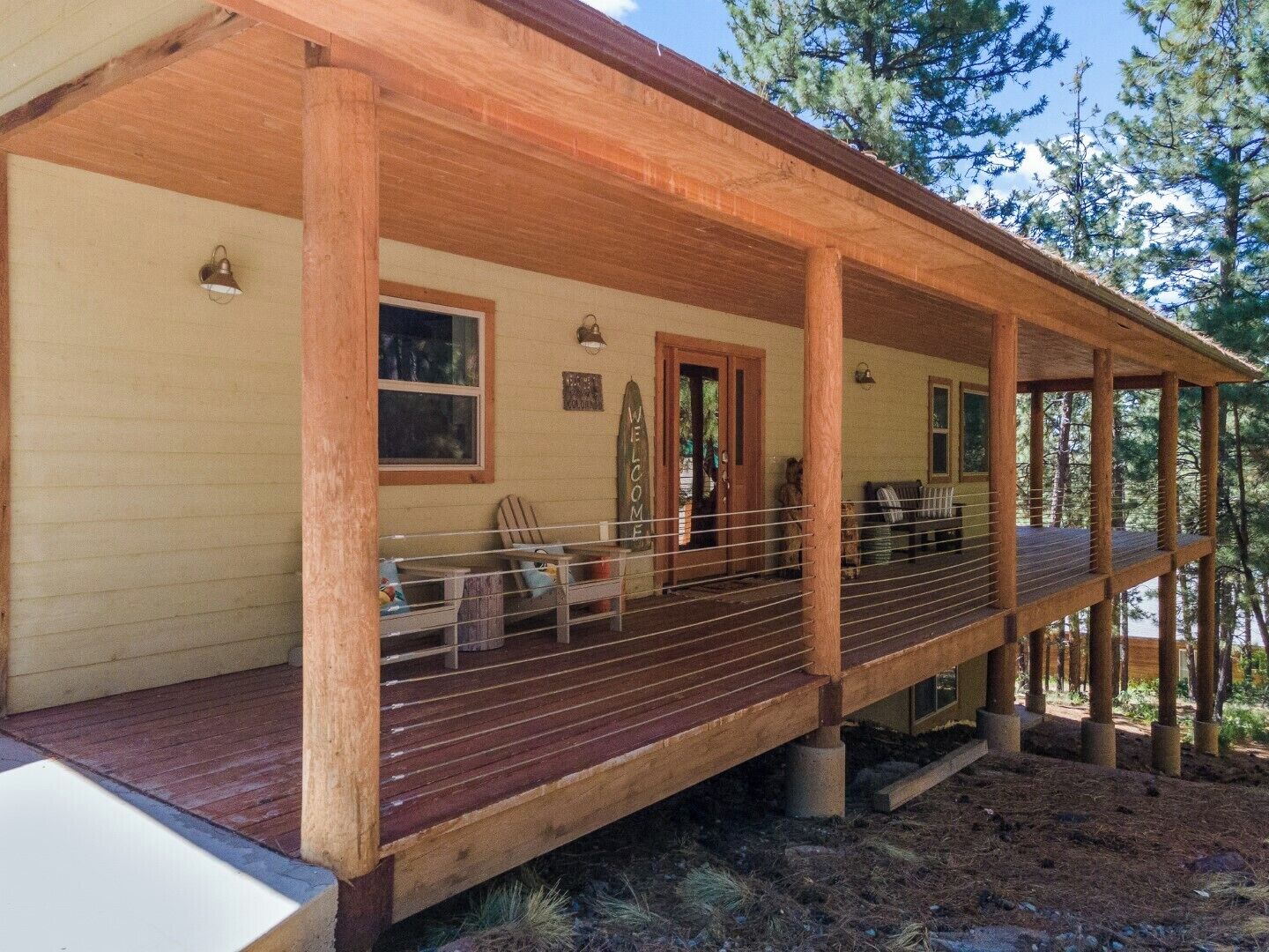 Une cabane en bois avec une véranda, une porte et une fenêtre.