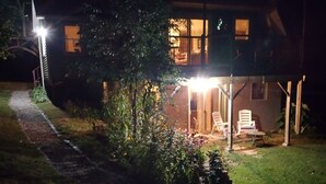 Ein Haus mit überdachter Veranda, einem Weg zum Eingang und einem kleinen Garten.