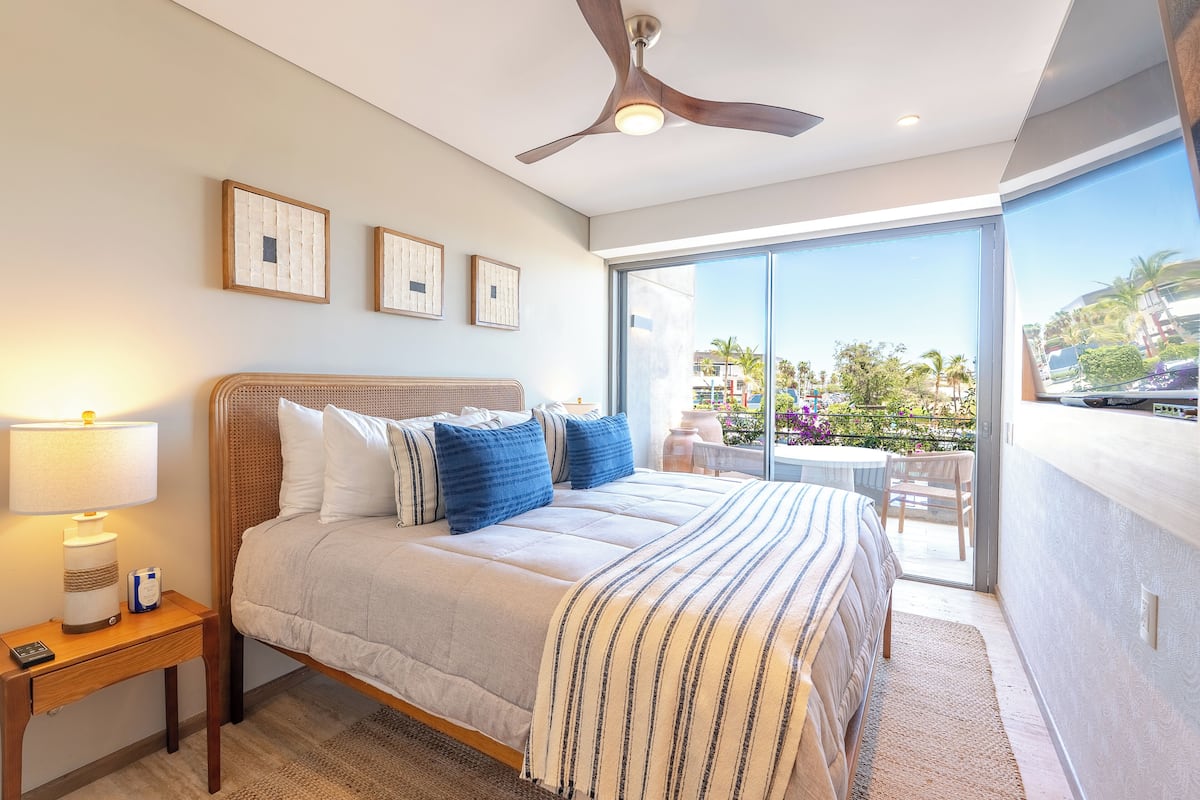 A bedroom with a bed, bedside table, and a ceiling fan.