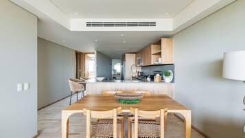 Een moderne keuken met houten kastjes, een centraal eiland en een eethoek met een houten tafel en stoelen.