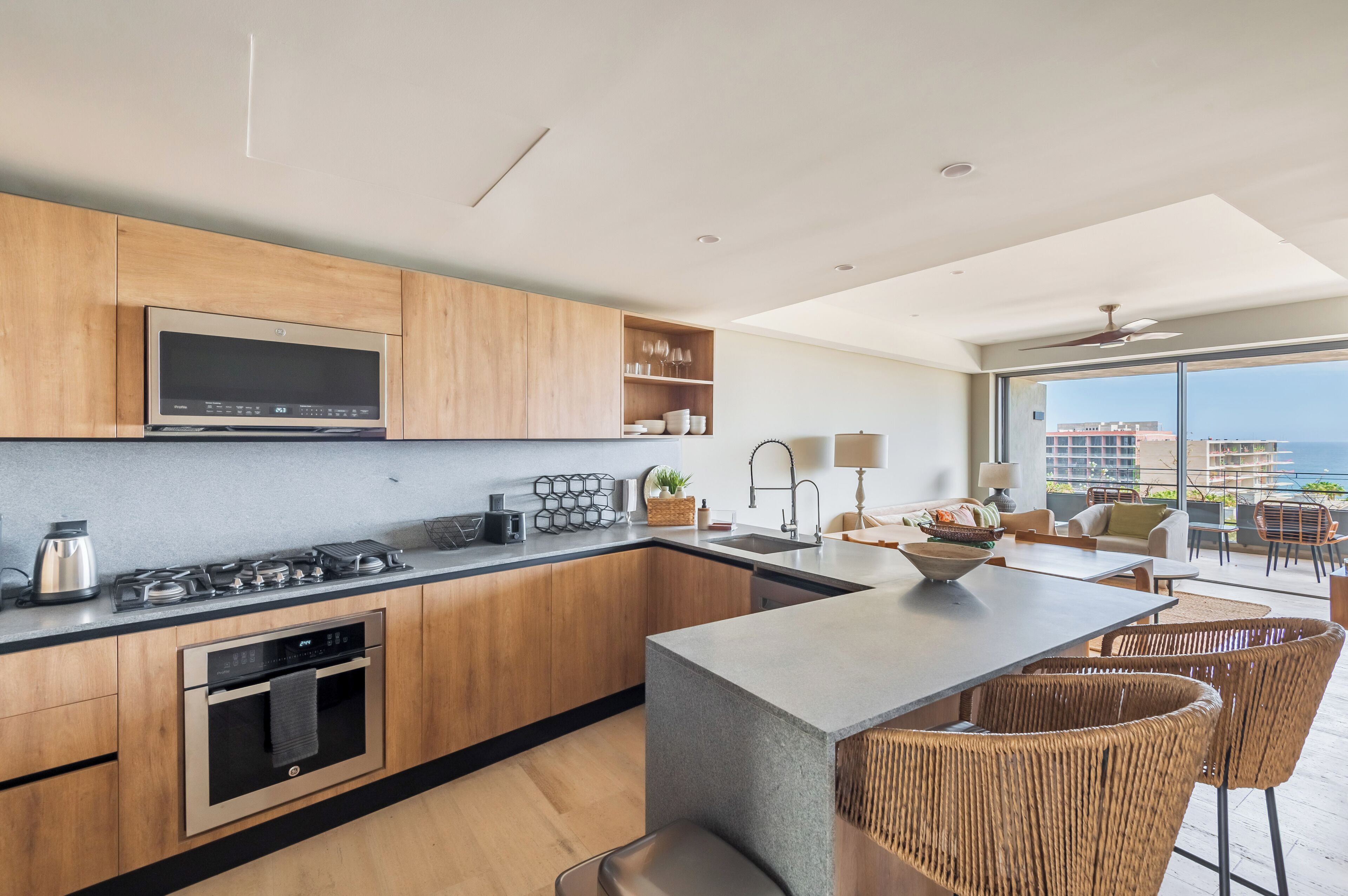 Une cuisine moderne avec des meubles en bois, des appareils en acier inoxydable et un grand îlot central.