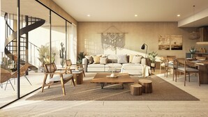 Un salon moderne avec un grand canapé, une table basse en bois et un coin repas comprenant une table et des chaises en bois.