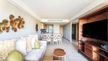 Una sala de estar moderna con sofá, mesa de centro y mueble de entretenimiento.