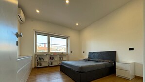 Ein Schlafzimmer mit einem Bett, Nachttischen, einem Kleiderschrank und eingebauten Bücherregalen.