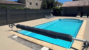 A rectangular swimming pool with a clear blue water, surrounded by a concrete deck. There are lounge chairs along the poolside. - Gîte Lavande*Clim*Terrace*Community pool (Saint-Paul-Trois-Châteaux)