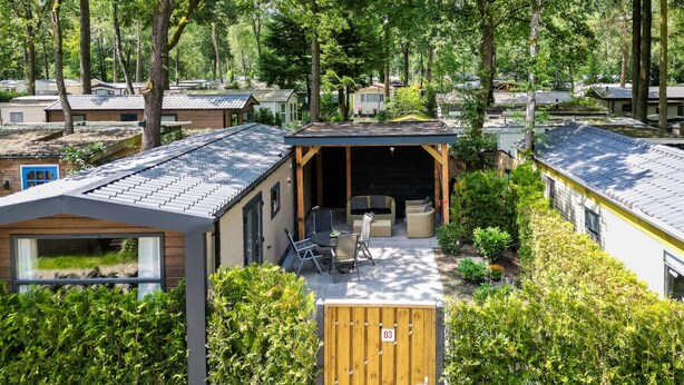 Een woonwijk met meerdere huizen, elk met een eigen daksysteem en omringd door groen.