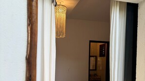 Un dormitorio con cama, lámpara colgante y puerta con cerradura.