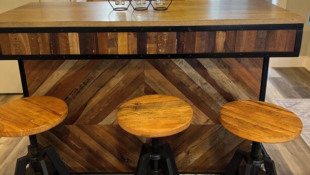 Eine Küche mit einer Holzhocker-Bar und einem hängenden Licht.