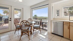 A spacious balcony with a dining area, a ceiling fan, and a view of the ocean. - Pet friendly house across from the ocean, 30 day minimum stay (Fernandina Beach)