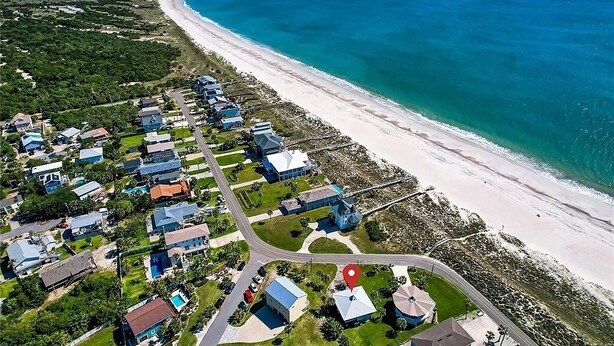 An aerial view of a coastal residential area with houses, a beach, and a clear blue ocean. - Pet friendly house across from the ocean, 30 day minimum stay (Fernandina Beach)