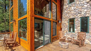 Una terraza de madera con mobiliario exterior y un muro de piedra.