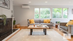 Ein modernes Wohnzimmer mit einer Sofagarnitur, einem Couchtisch und einem Kamin.