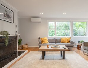 A modern living room with a sofa set, a coffee table, and a fireplace.
