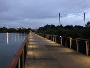 A long, narrow bridge with a metal railing and a textured walkway. - Comfortable Cosy Apartment| by Furnished Rentals (Auckland)