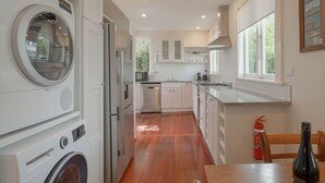 A modern kitchen with built-in appliances, a dining area, and a view of the outdoors.