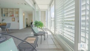 Ein modernes Interieur mit Essbereich, Küche und einem Balkon mit großen Fenstern.