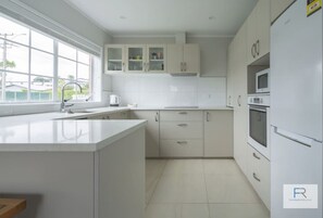 Fridge, microwave, oven, stovetop - Cosy Bayswater House|by Furnished Rentals (Auckland)